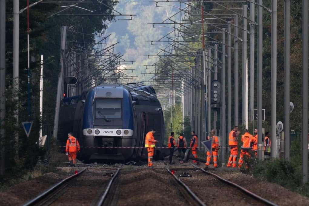 SNCF agents walk around a crashed train in Cleon, northwestern France, on Saturday, one day after a train carrying 180 passengers derailed, injuring 44 people. Photo: AFP