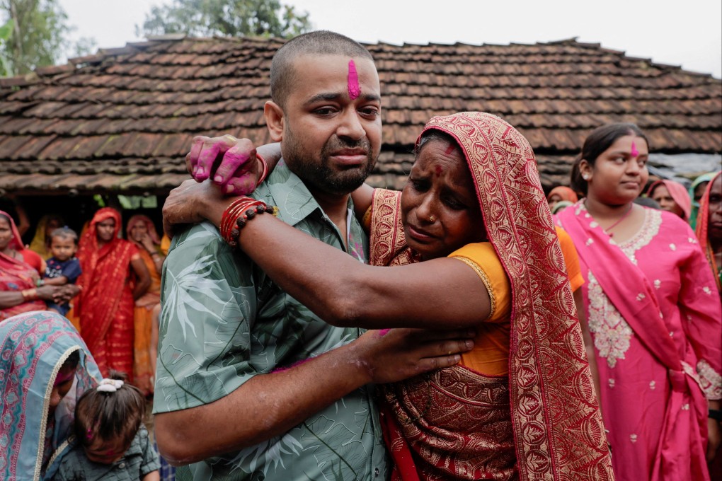 Sanjay Sah, a survivor pulled out alive after spending nine days trapped in a hydropower station tunnel following flash floods and a mudslide, embraces his mother, Kapur Devi Sah, upon his arrival at their house in Tilathi Koiladi village in Saptari District, Nepal, on Sunday. Photo: Reuters