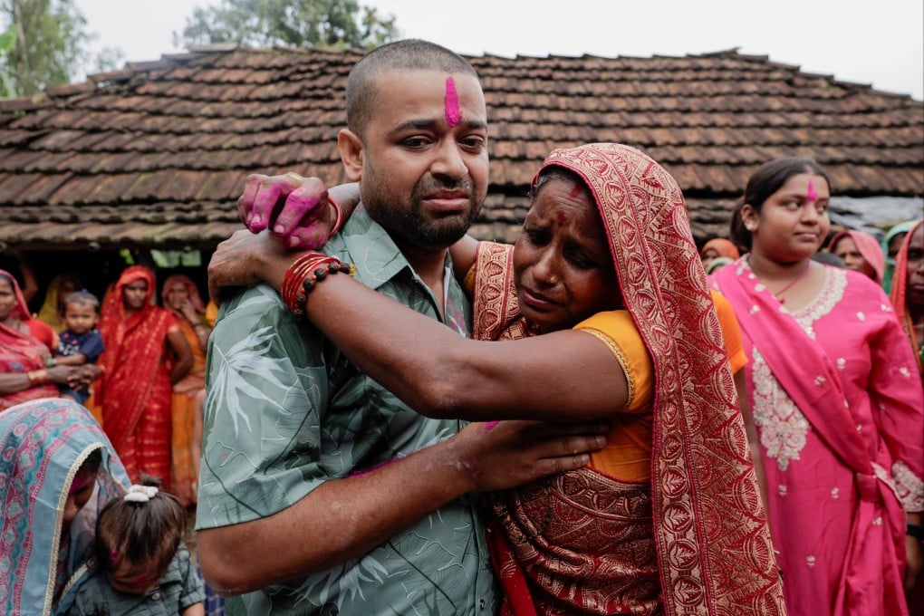 Sanjay Sah, a survivor pulled out alive after spending nine days trapped in a hydropower station tunnel following flash floods and a mudslide, embraces his mother, Kapur Devi Sah, upon his arrival at their house in Tilathi Koiladi village in Saptari District, Nepal, on Sunday. Photo: Reuters