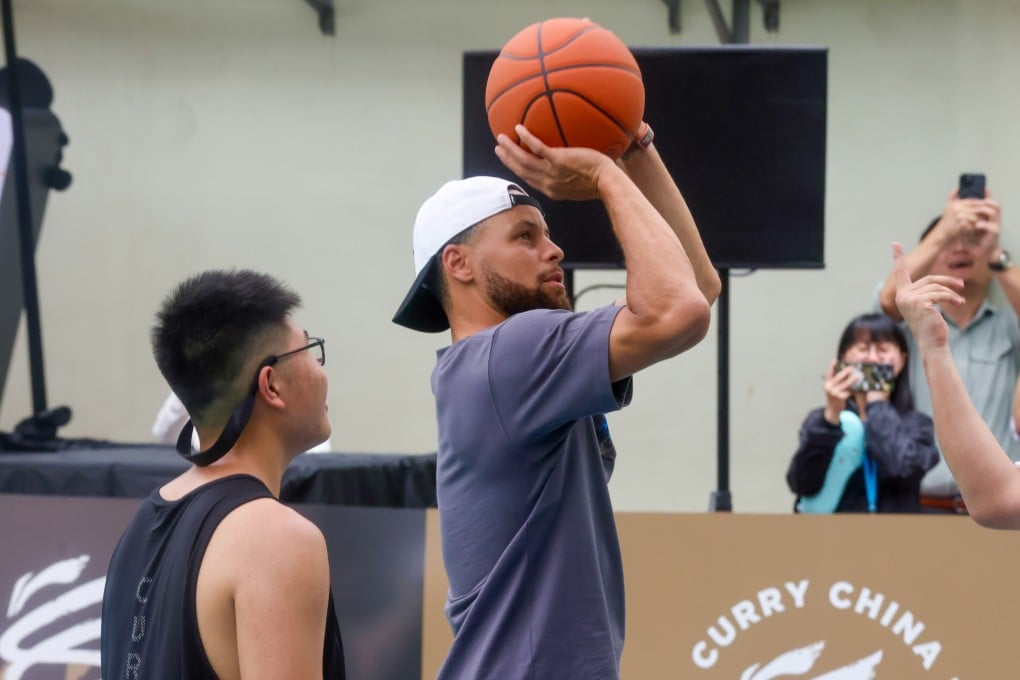 NBA star Stephen Curry takes a shot during his visit to Shun Tak Fraternal Association Leung Kau Kui College Estate Secondary School. Photo: Jonathan Wong