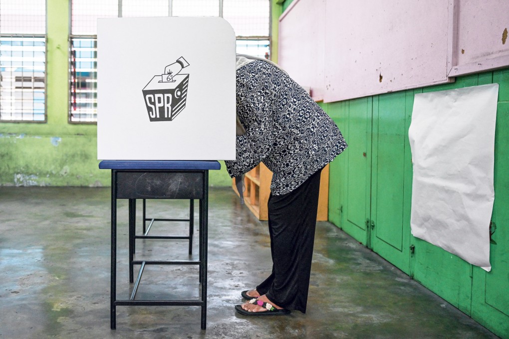A woman casts her vote at a polling station during a state election in Malaysia in 2023. Photo: AFP