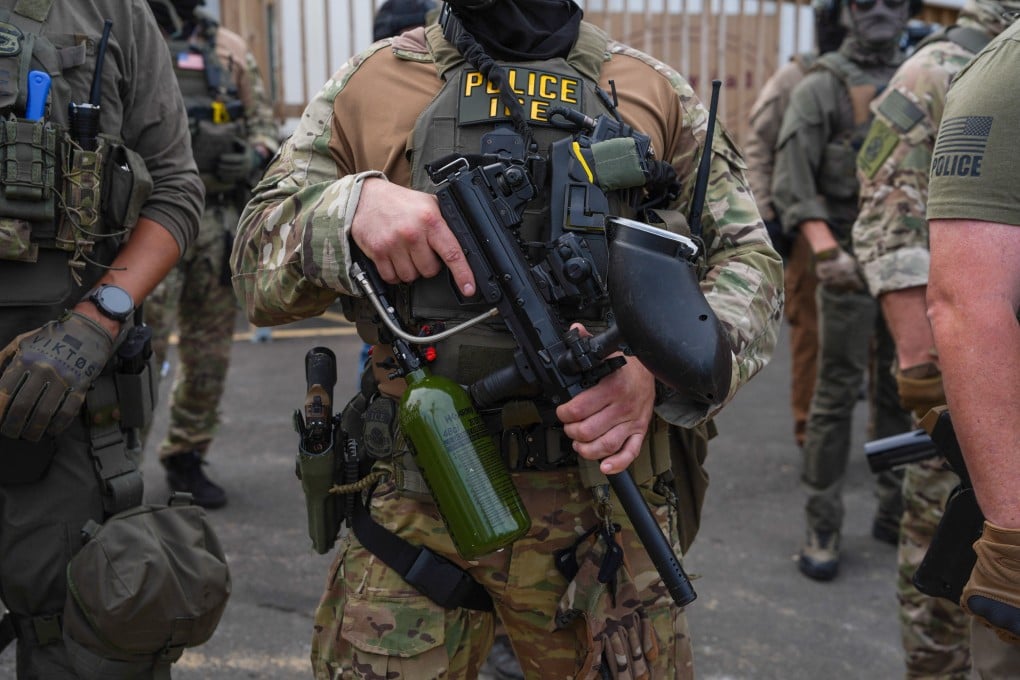 Immigration and Customs Enforcement agents stand guard holding less-lethal weapons as protesters gather outside Delaney Hall, which is being used as an ICE detention center, in Newark, New Jersey, in June. Photo: AFP/Getty Images/TNS