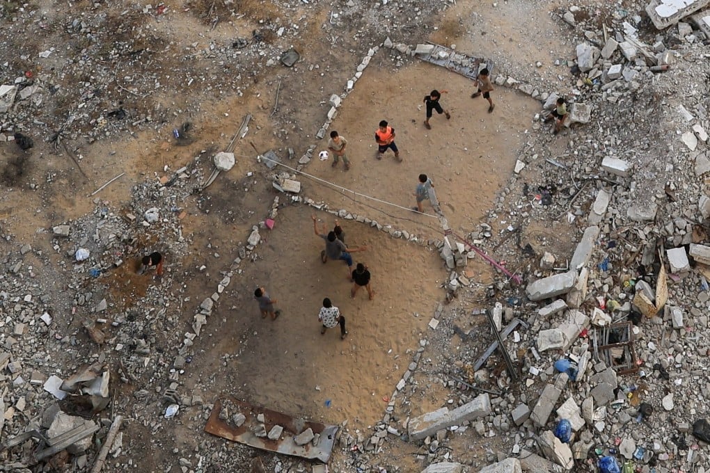 Palestinian children play volleyball amid the rubble of destroyed buildings in Gaza City. Photo: Reuters
