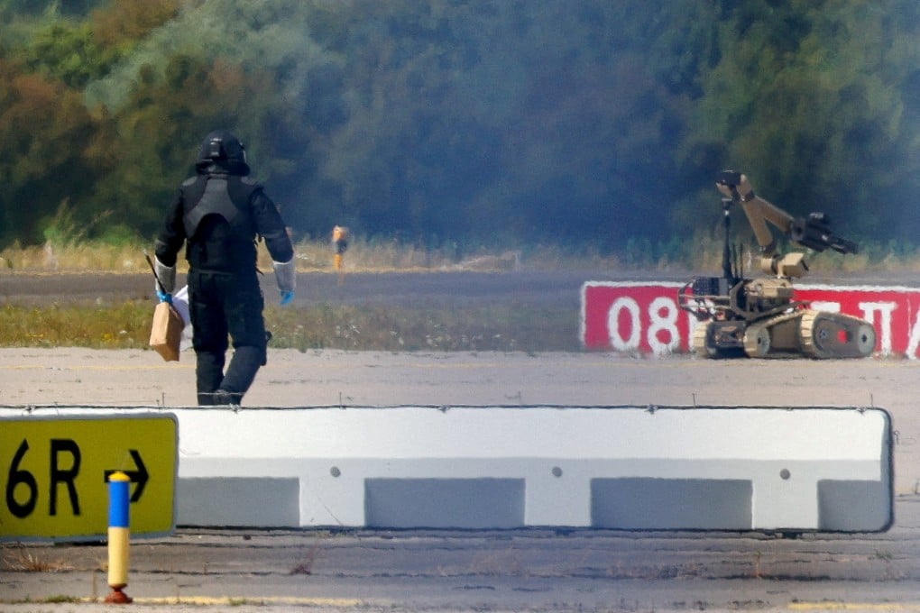 A police officer walks next to an explosive-disarming robot at Germany’s Leipzig airport last month after a drone was found near a runway. Photo: Reuters
