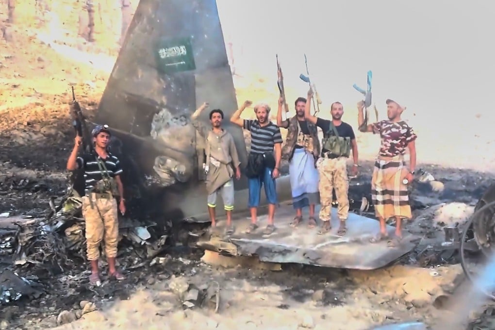 Houthi fighters pose atop what the group described as the wreckage of a downed Saudi F-15 fighter jet in Marib province, Yemen, in an image released on Wednesday. Photo: Ansar Allah Media Office via AP