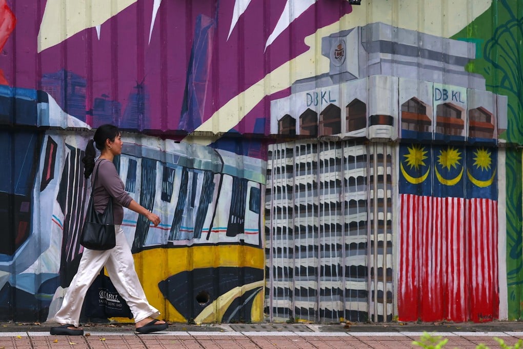 A woman walks against a mural in Kuala Lumpur in August. A Malaysian court has acquitted a 15-year-old boy of murdering his schoolmate on the grounds that severe schizophrenia had left him legally insane. Photo: EPA