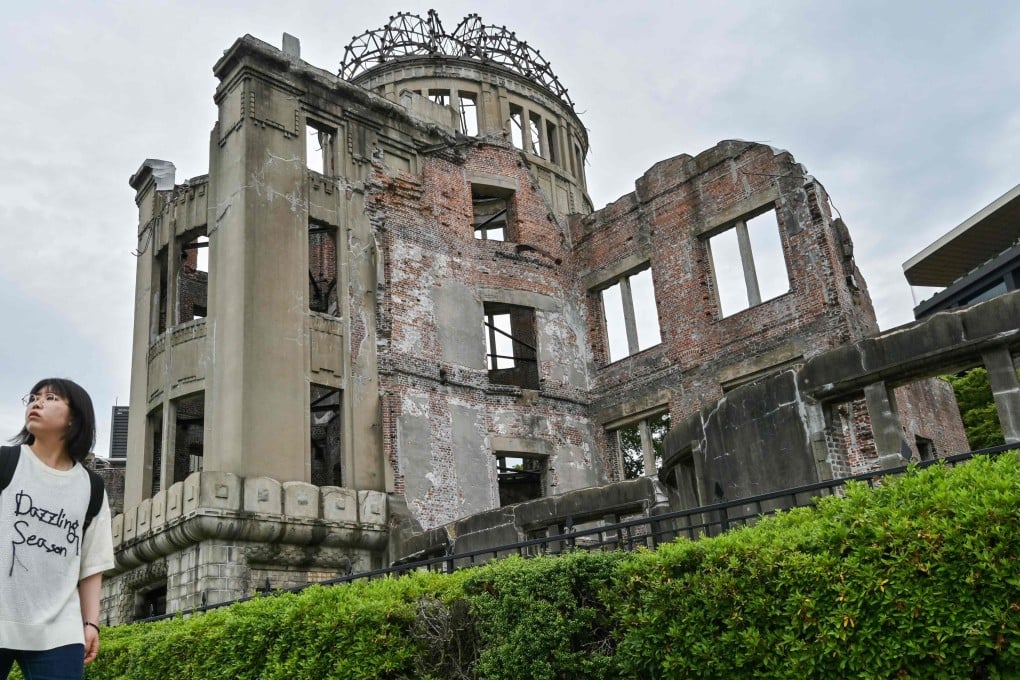 A woman walks past the Atomic Bomb Dome in the centre of Hiroshima in 2025, ahead of the 80th anniversary of the bombing of Hiroshima and Nagasaki. Photo: AFP