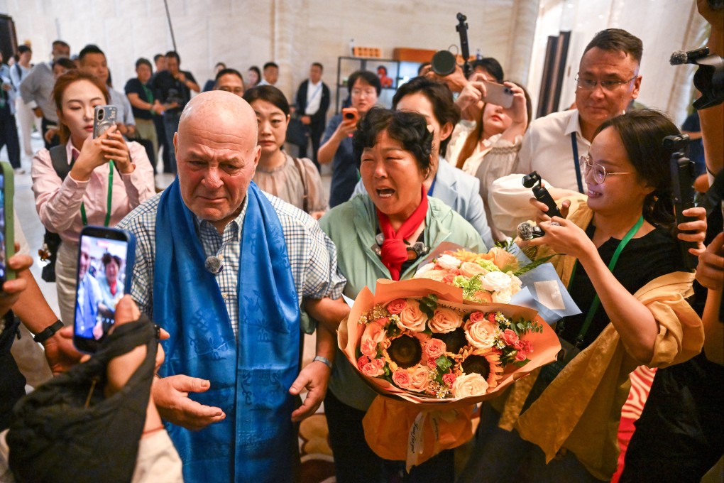 Yin Yuzhen, now a ‘national model worker’, and retired American teacher Ronald Sakolsky at an airport in Ordos in China’s Inner Mongolia autonomous region, on August 23. Photo: Xinhua