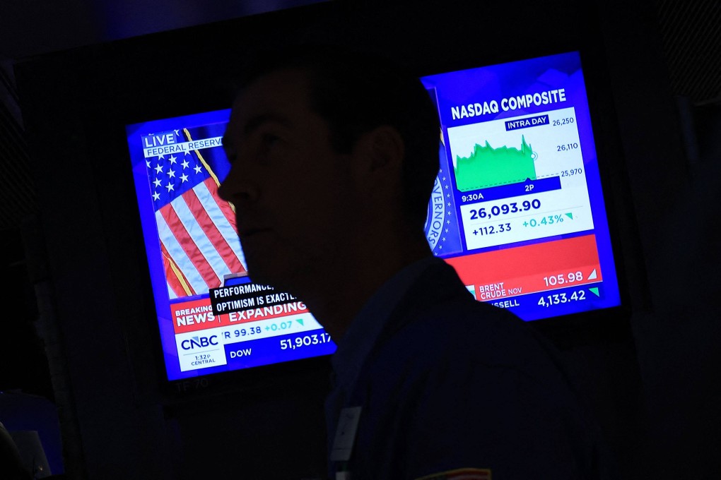 A television displays news of the US Federal Reserve’s interest rate hike as traders work on the floor of the New York Stock Exchange in New York on September 16. Photo: AFP