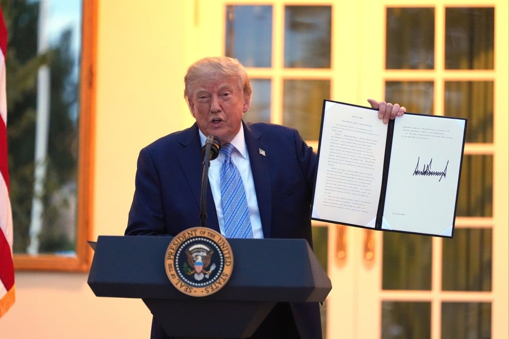 US President Donald Trump displays signed orders during a dinner in the Rose Garden of the White House in Washington on Friday. Photo: AP