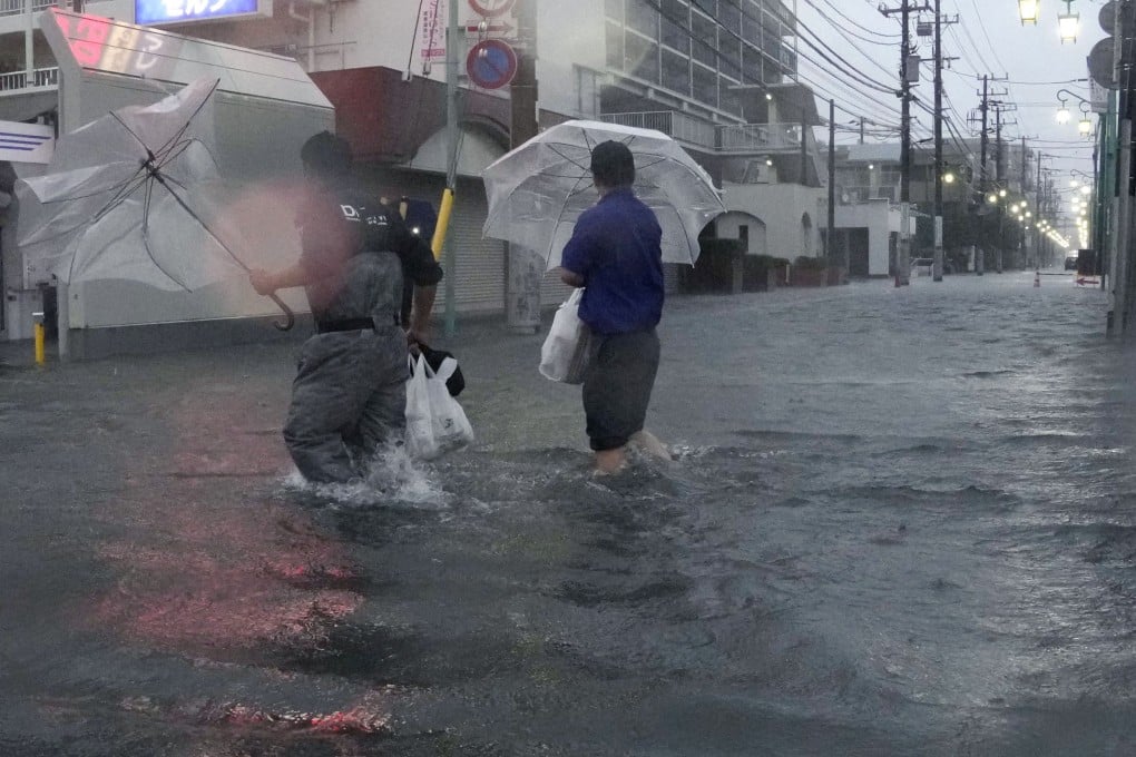 People walk along a road flooded by heavy rain on Monday in Ichikawa, Chiba Prefecture, near Tokyo. Photo: Kyodo