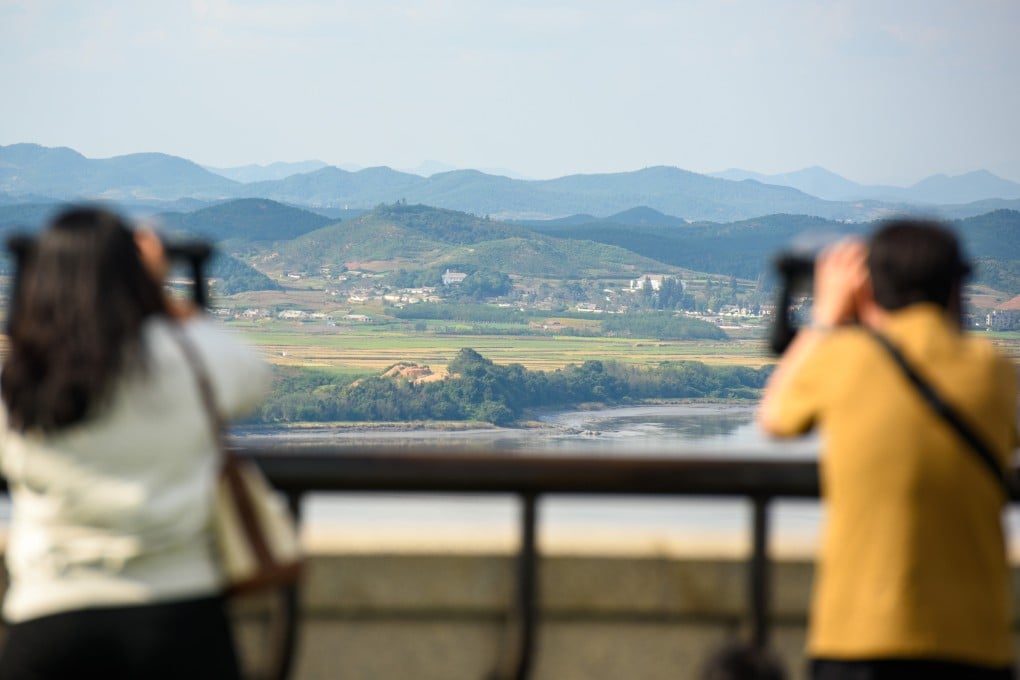 Visitors use binoculars to look at the North Korean side of the demilitarised zone dividing the two Koreas. Photo: Sopa Images/LightRocket/Getty Images