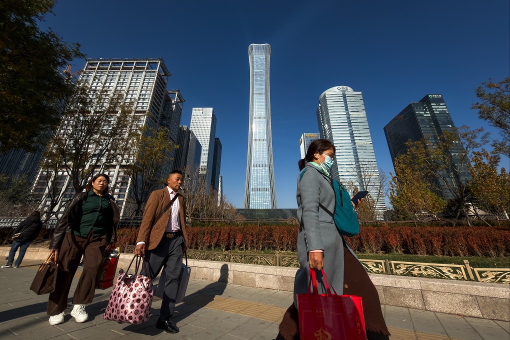 People carry bags while walking through the central business district in Beijing. Photo: Getty Images