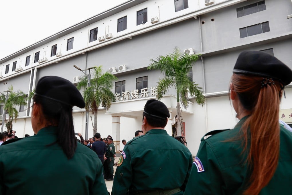 Cambodian police officers stand guard outside a closed complex in Kandal province on Tuesday, following a raid to dismantle suspected scam and cyber-fraud operations. Photo: EPA