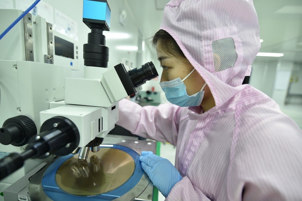 A worker examines a wafer in a dust-free workshop at a semiconductor company in China’s Jiangsu province. Photo: Getty Images