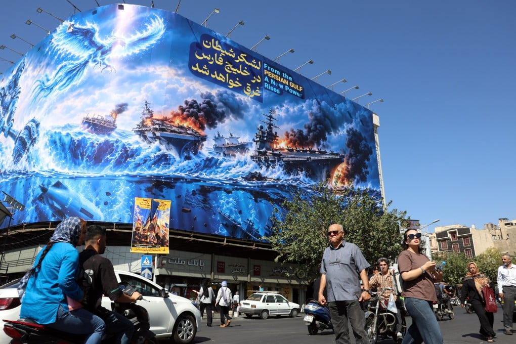 Iranians walk next to an anti-US billboard carrying a sentence in Persian that reads “The devil army will be drowned in the Persian Gulf” in Tehran on Monday. Photo: EPA