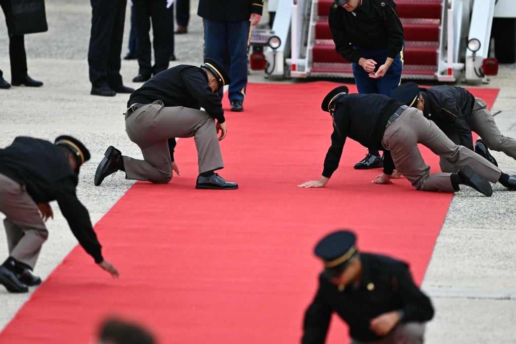 US military personnel adjust the red carpet at the foot of the stairs to the Air China plane carrying Chinese President Xi Jinping. Photo: AFP
