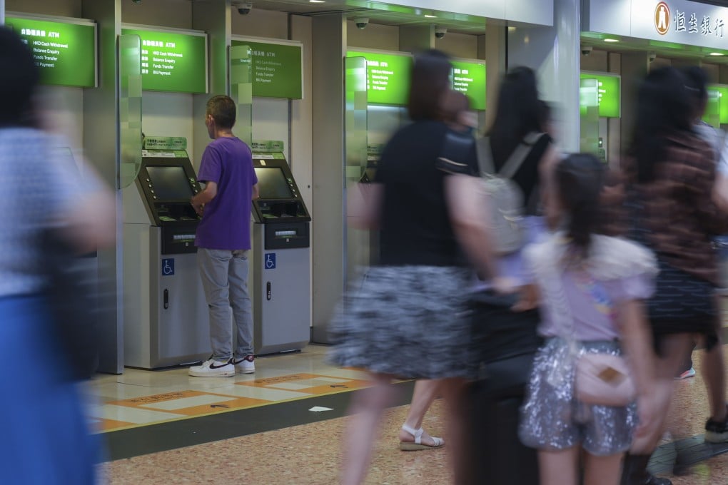A person uses an ATM at a bank branch in Mong Kok. Photo: Eugene Lee