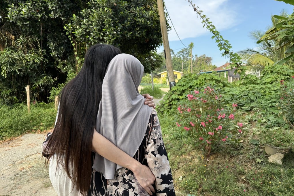 Hana* (left) embraces her mother outside their home in a village near Kota Bharu, Malaysia’s Kelantan state. Photo: Iman Muttaqin Yusof