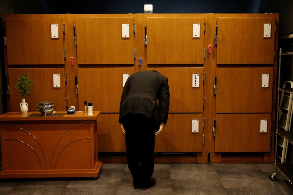 An undertaker bows after putting a casket in a morgue in Tokyo in 2017. Photo: Reuters