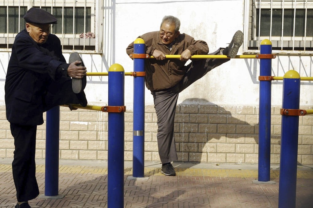 Two elderly Beijing residents stretch at an exercise park. Photo: AFP/File photo