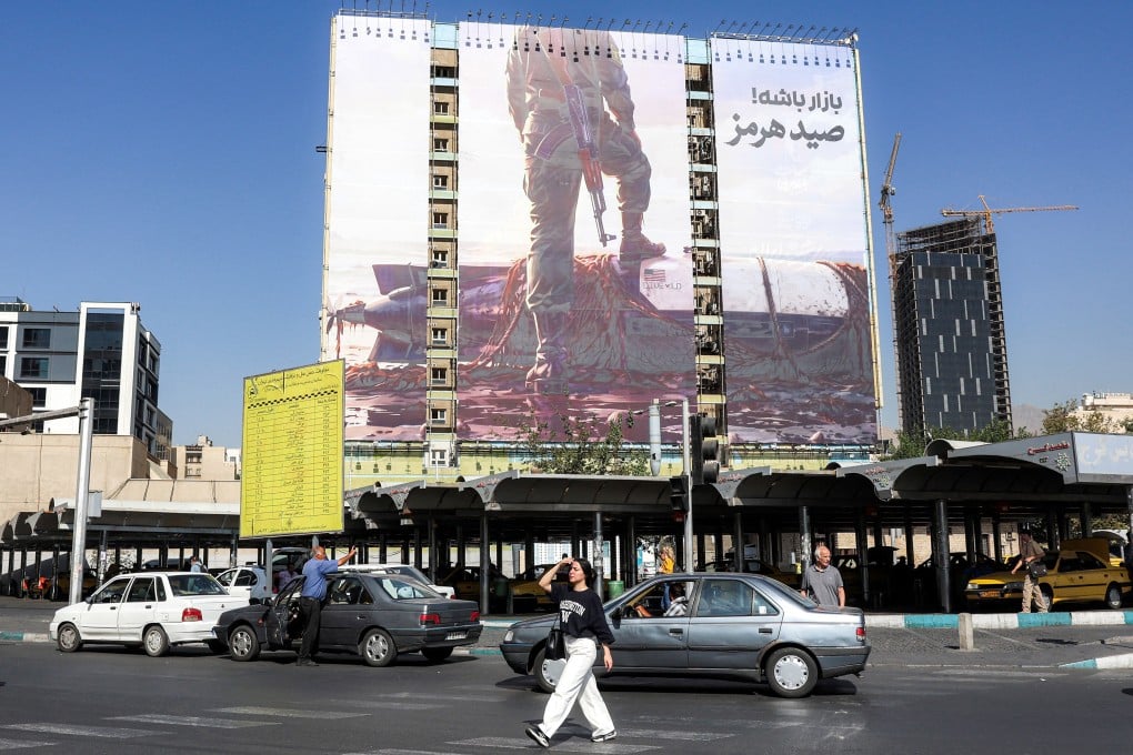 A woman crosses a street near a giant anti-US billboard in Tehran, Iran, on Thursday. Photo: TNS