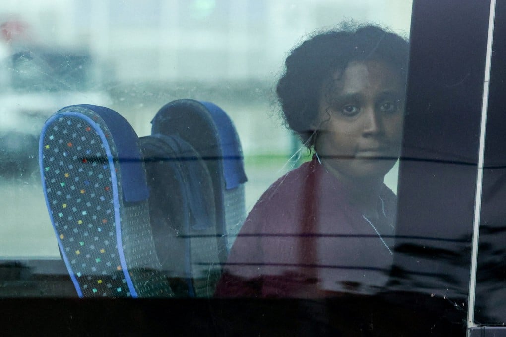 A migrant sits in a bus as she leaves the rescue area of the French port of Calais on Monday. Three other migrants, including a child aged 10, died while attempting to cross the sea to Britain. Photo: Reuters