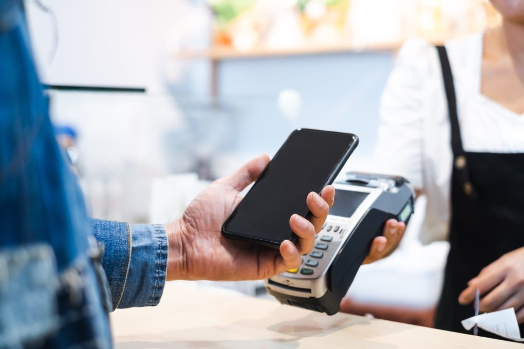 A customer pays via smartphone at a cafe restaurant. Austrlian cafe owners are raising food and coffee prices to offset bank processing fees as the country bans card payment surcharges. Photo: Shutterstock