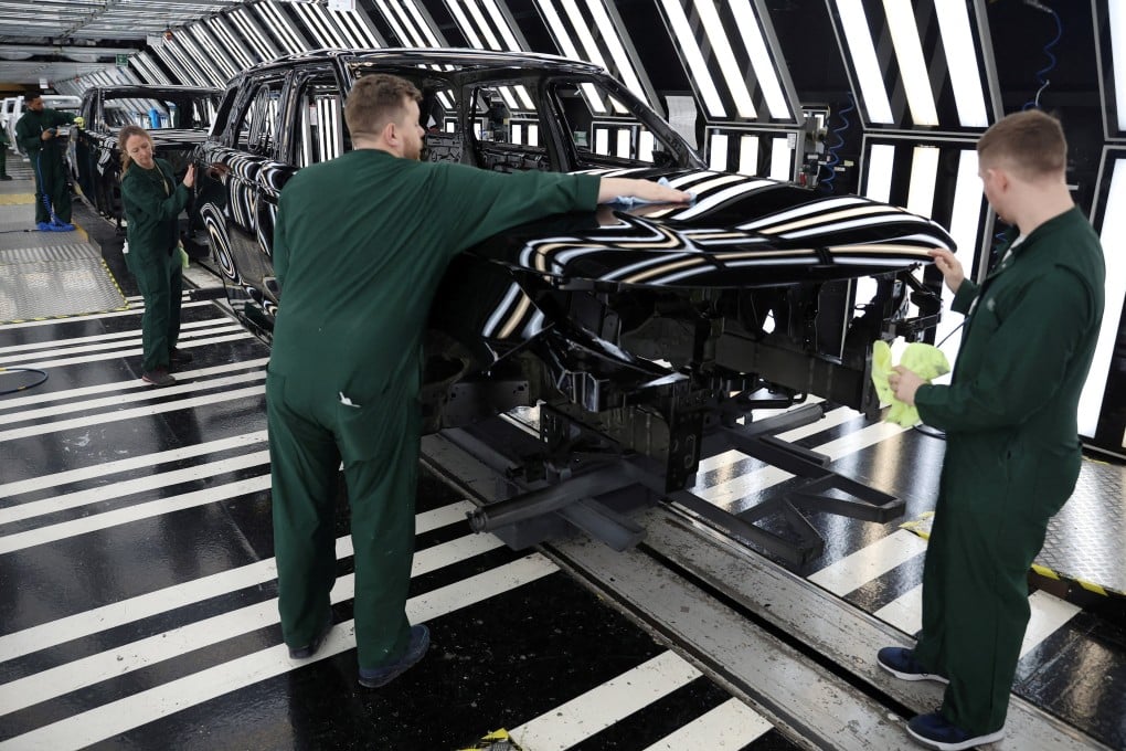 Members of staff check the paintwork on Range Rover bodies as they pass through the paint shop at Jaguar Land Rover’s factory in Solihull, Britain. Photo: Reuters