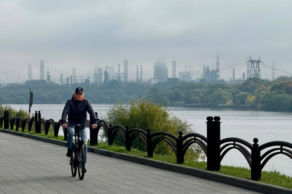 A man rides a bicycle on an embankment of the Moskva river, with the Russian oil producer Gazprom Neft’s Moscow oil refinery in distance, on the southeastern outskirts of Moscow last month. Photo: AFP