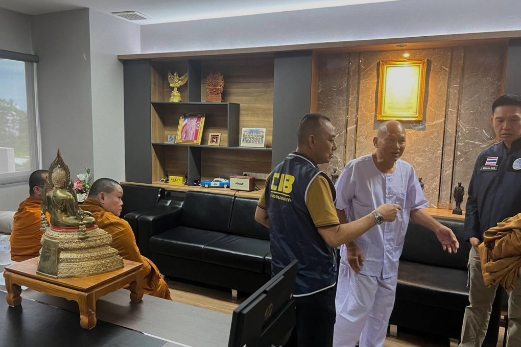 Alongkot Poonmook, formerly known as Phra Ratcha Wisutthiprachanat (second from right in white) talks to police personnel at the Central Investigation Bureau in Bangkok, Thailand, on August 26, 2025. Photo: Central Investigation Bureau via AP