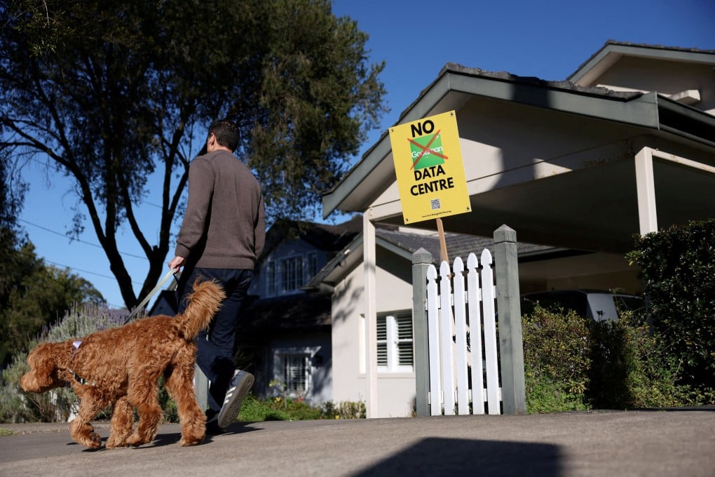 A man walking a dog passes a sign that says “No Goodman Data Centre” outside a home in Sydney, Australia, on August 14. Photo: Reuters