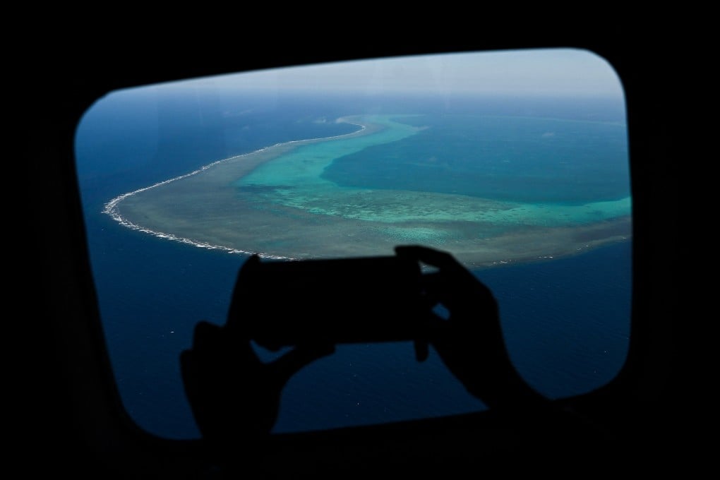 A reporter takes a video over Scarborough Shoal in the South China Sea in February 2024. Photo: AFP