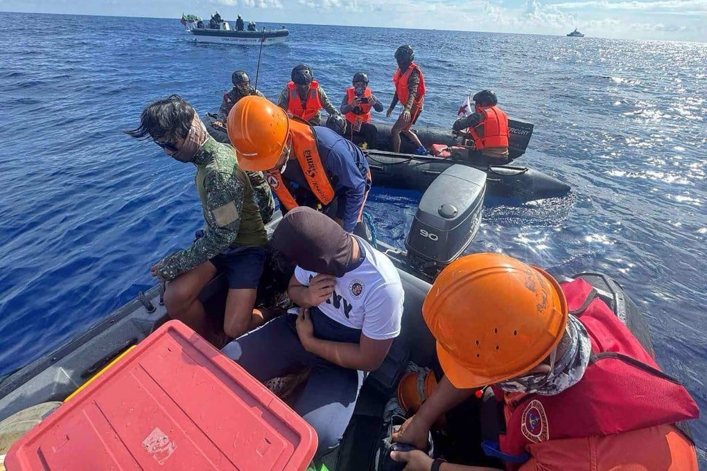 Philippine Navy personnel transfer a colleague to a Philippine Coast Guard rigid boat while Chinese Coast Guard personnel aboard their rigid boat watch, during a medical evacuation near Second Thomas Shoal in the disputed South China Sea. Photo: Philippine Coast Guard/AFP