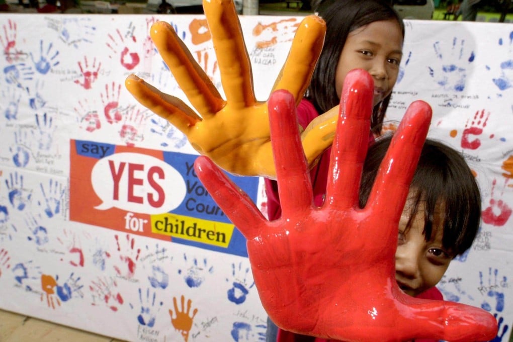 Two rescued Filipino child labourers show their painted hands before a ceremony to improve the lives of children held at the Malacanang presidential palace in Manila in 2001. Photo: AFP