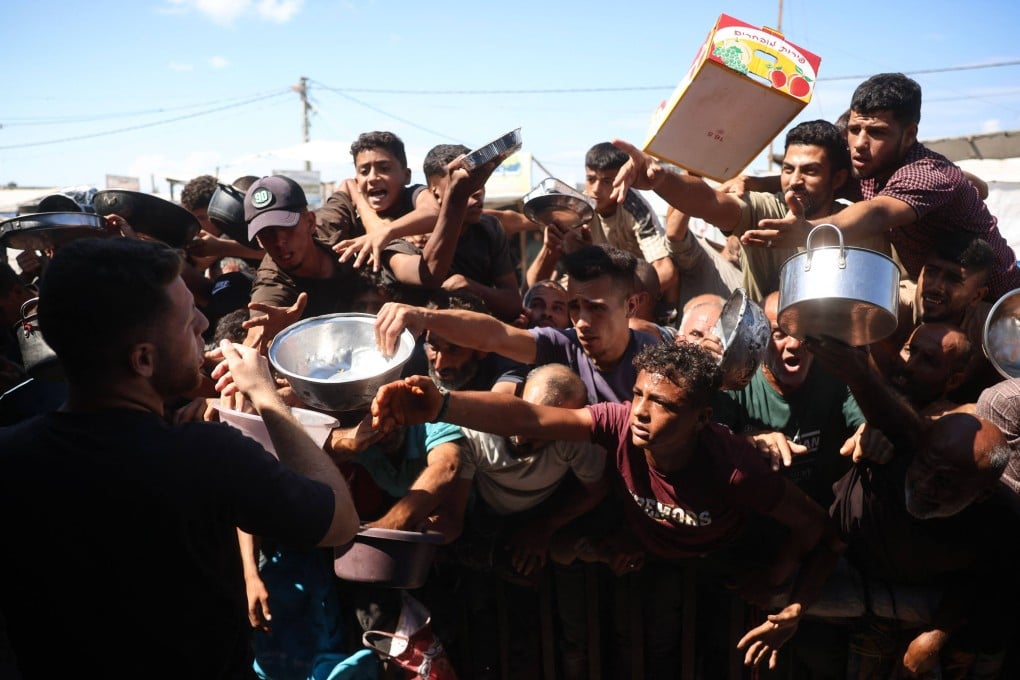Displaced Palestinians wait to receive food at a charity kitchen in Khan Yunis, in the southern Gaza Strip on Monday. Photo: AFP