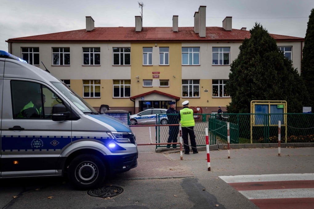 Police officers stand in front of the school where a 15-year-old fatally stabbed the caretaker of his former school and wounded two other adults at the John-Paul II primary school in Leszczydol-Nowiny, Poland, on Thursday. Photo: AFP
