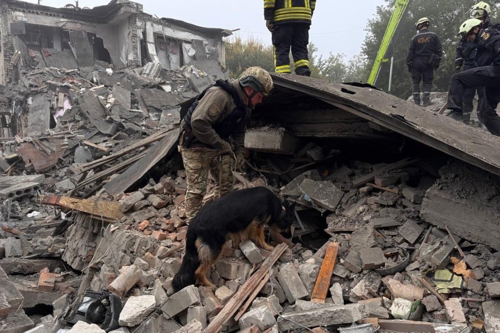 A police officer with a dog searching for people under the rubble of a five-storey residential building following a Russian attack that killed seven people, including three children, in Zaporizhzhia, on Saturday. Photo: AFP