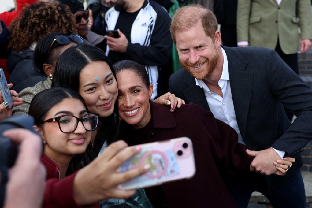 Britain’s Prince Harry and Meghan, Duchess of Sussex, pose for a selfie with fans in Nottingham on Thursday. Photo: AFP