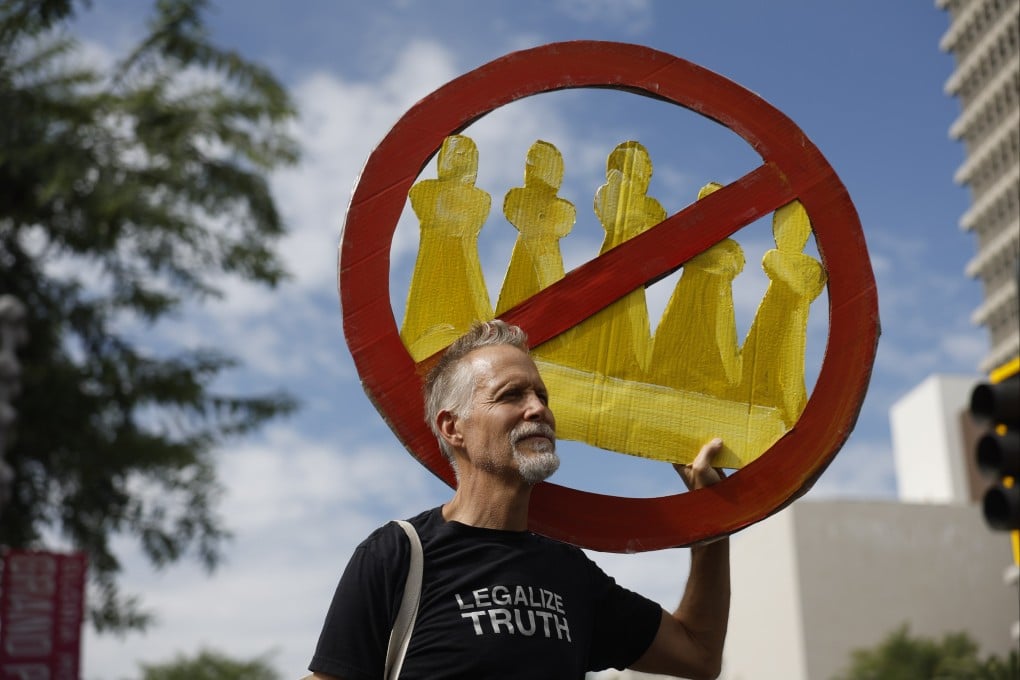 A demonstrator holds a “No Kings” sign during a protest in Los Angeles on Saturday. Photo: AP