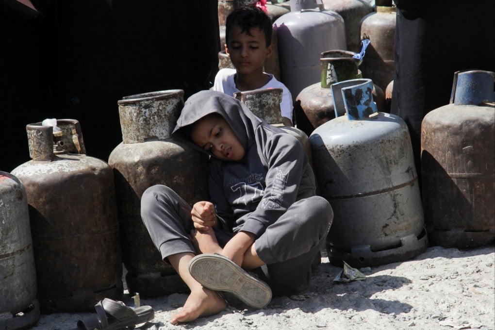 Boys sit as they wait in a queue to fill up cooking gas cylinders in the southwestern city of Taiz, the last major urban stronghold of anti-Houthi forces in the southern highland area of Yemen. Photo: Reuters