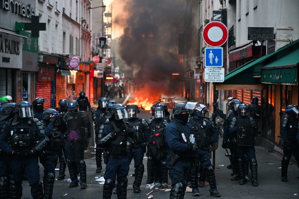 Police officers gather in front of a fire in a street as clashes erupted at Place de la Republique in central Paris following an unauthorised demonstration on Sunday. Photo: AFP