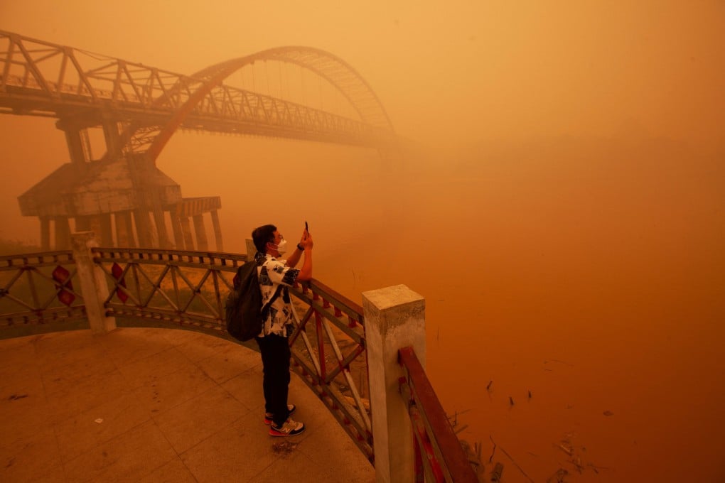 A man uses his smartphone to record the haze from wildfires that shrouds the area on the bank of the Kahayan River in Palangka Raya, Central Kalimantan, on Wednesday. Photo: Reuters