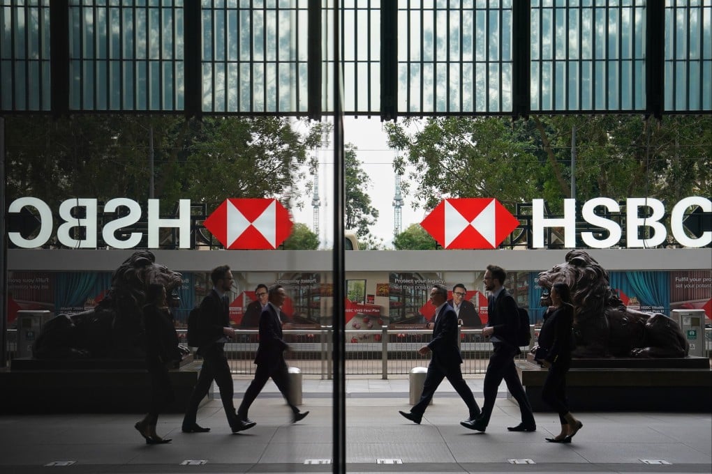 Pedestrians walk past the lion statues outside HSBC’s Hong Kong head office in Central. Photo: Elson Li