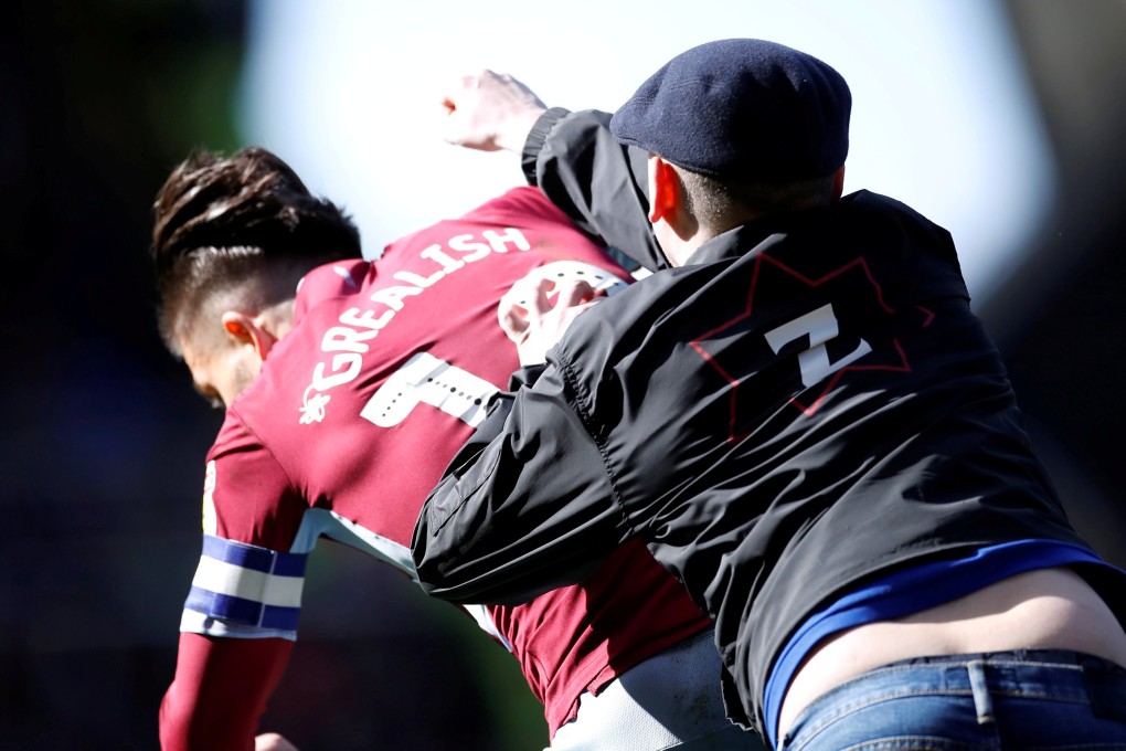 A Birmingham City supporter invades the pitch and attacks Aston Villa’s Jack Grealish. Photo: Reuters