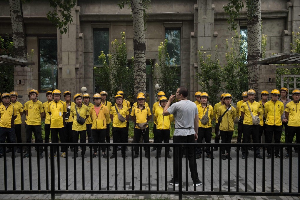 Food delivery workers of Chinese online on-demand services giant Meituan Dianping attend a morning briefing in Beijing. Photo: Agence France-Presse