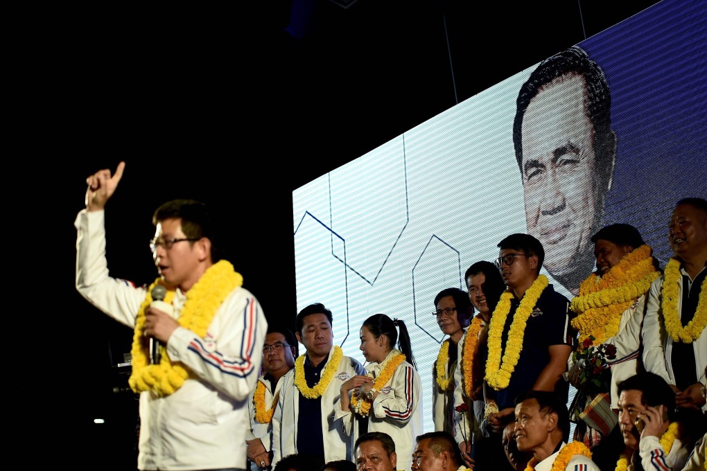Candidates for the pro-military Palang Pracharat Party in front of a picture of current Thai prime minister Prayuth Chan-Ocha during a rally. Photo: AFP