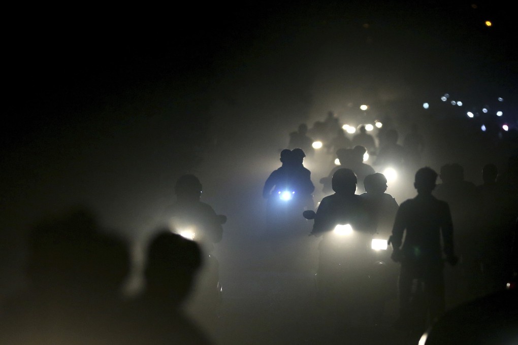 Motorists ride through a thick blanket of smog and dust on the outskirts of New Delhi, India. Photo: AP photo