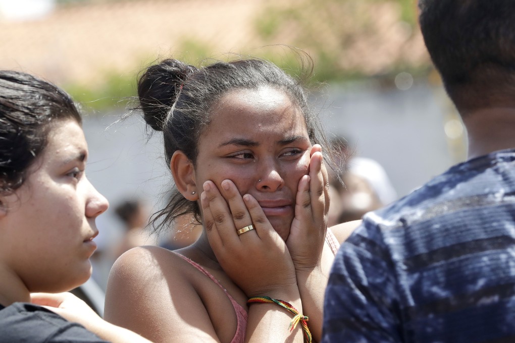 A student cries outside the Professor Raul Brasil school in Sao Paulo on Wednesday after attackers entered the school and began shooting at students. Photo: AP