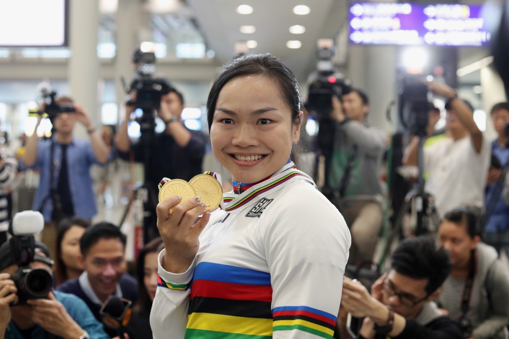 Hong Kong cyclist Sarah Lee Wai-sze holds up her gold medals at Hong Kong International Airport. Lee won gold in the women's sprint and keirin events at the world championships in Poland. Photo: Winson Wong
